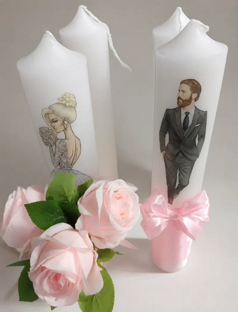 Lumânări albe pentru nuntă, decorate cu ilustrații ale mirilor și funde roz